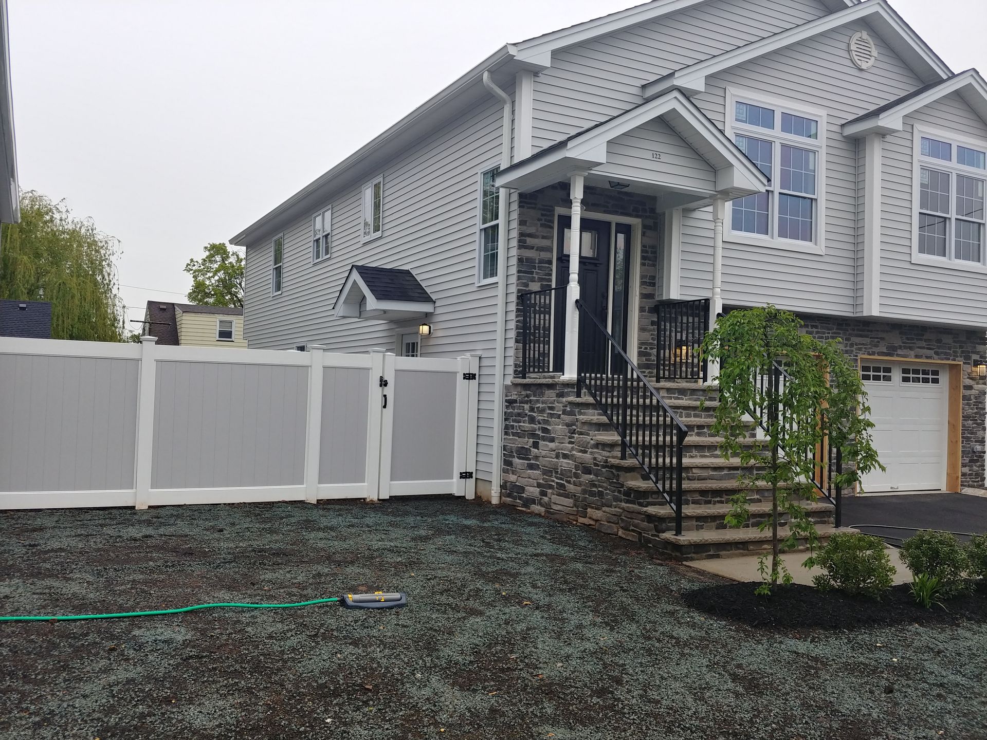 A large white house with a white fence in front of it.