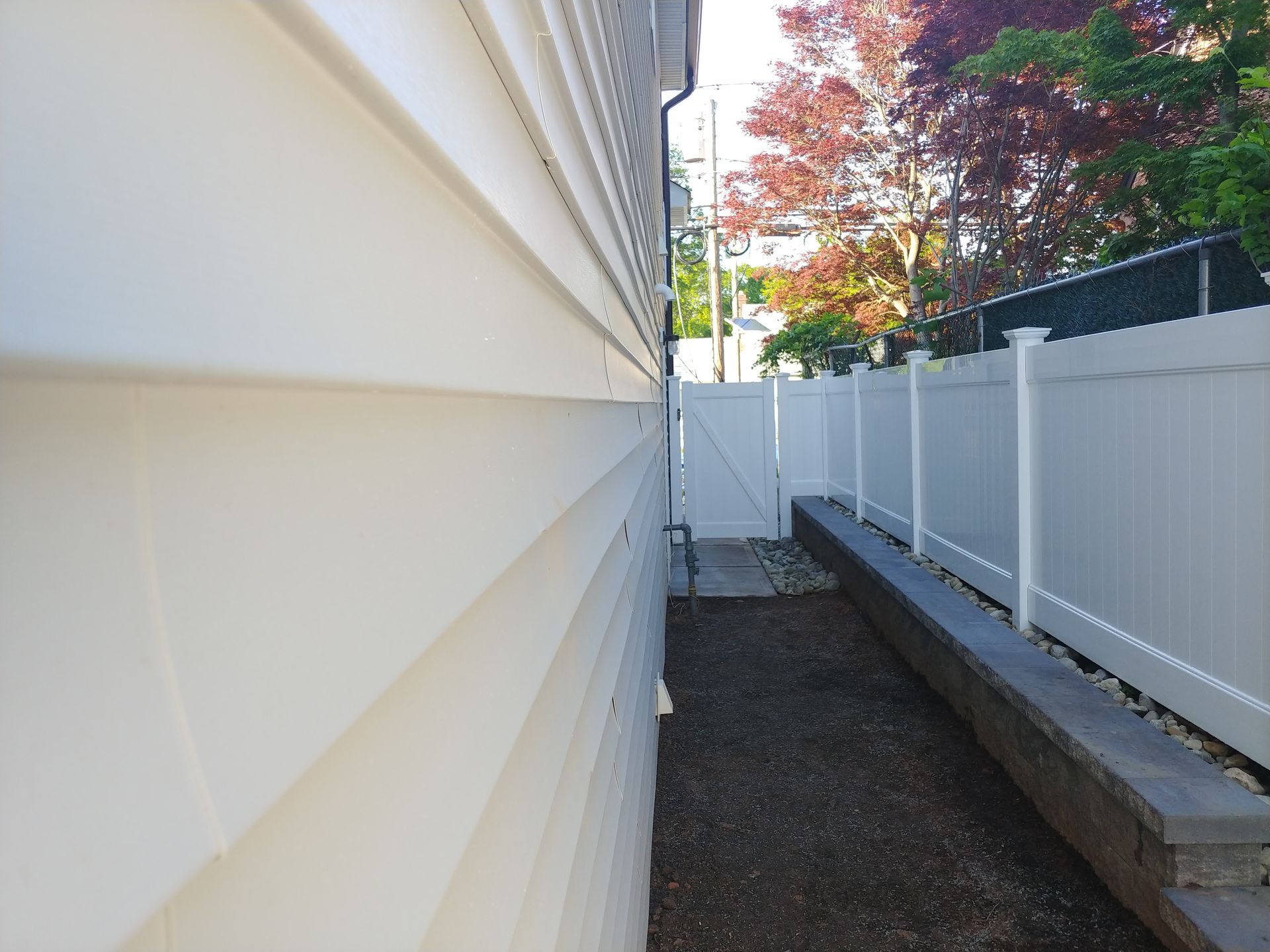 A white house with a white fence surrounding it