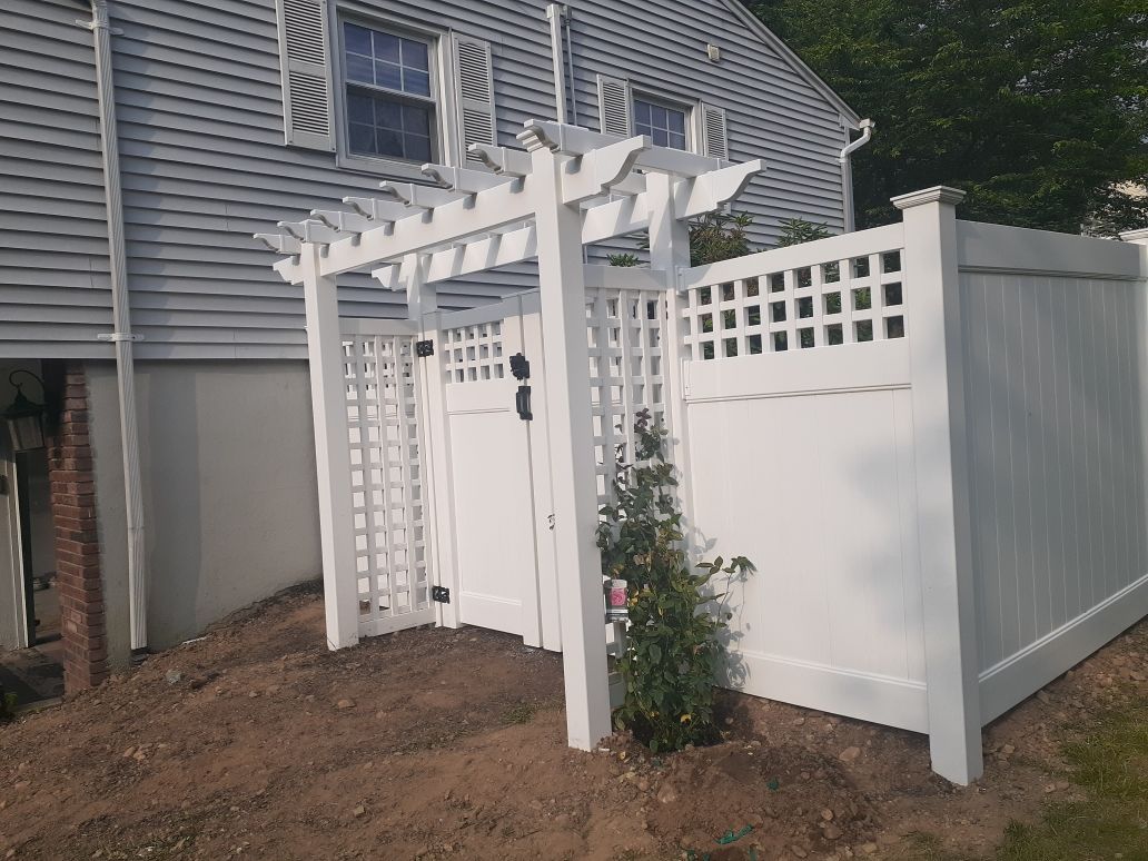 There is a wooden fence in the backyard of a house.