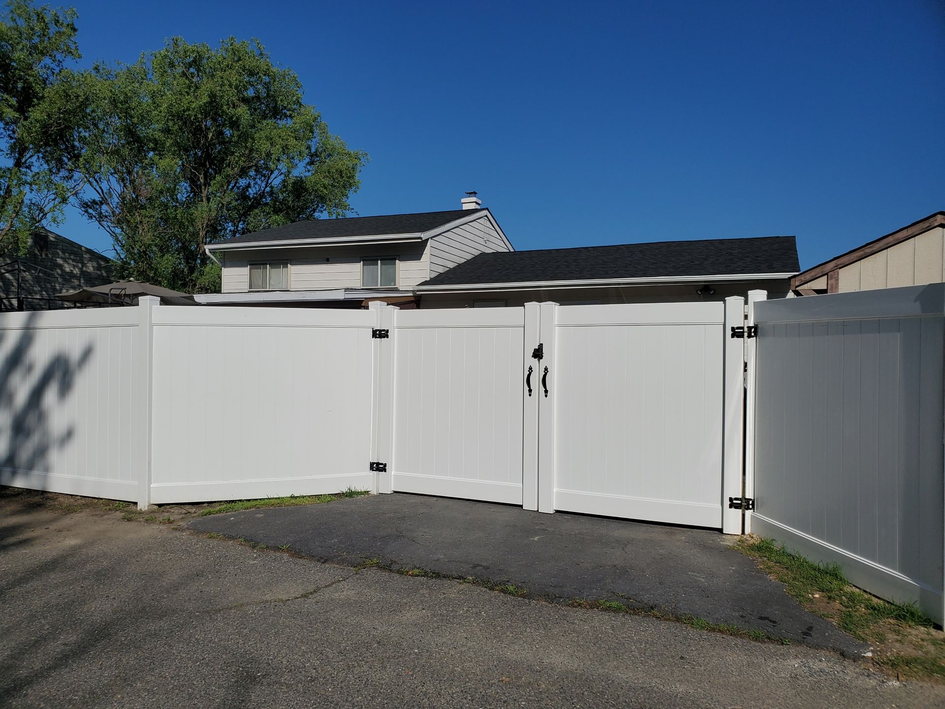 A white fence with a gate in front of a house
