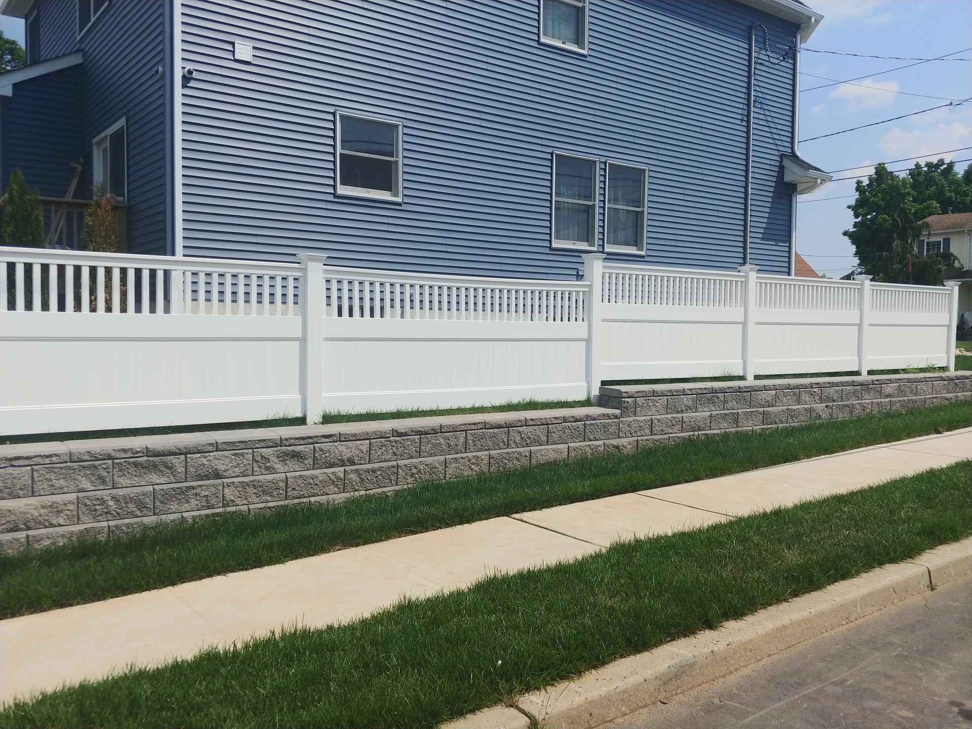 A blue house with a white fence in front of it