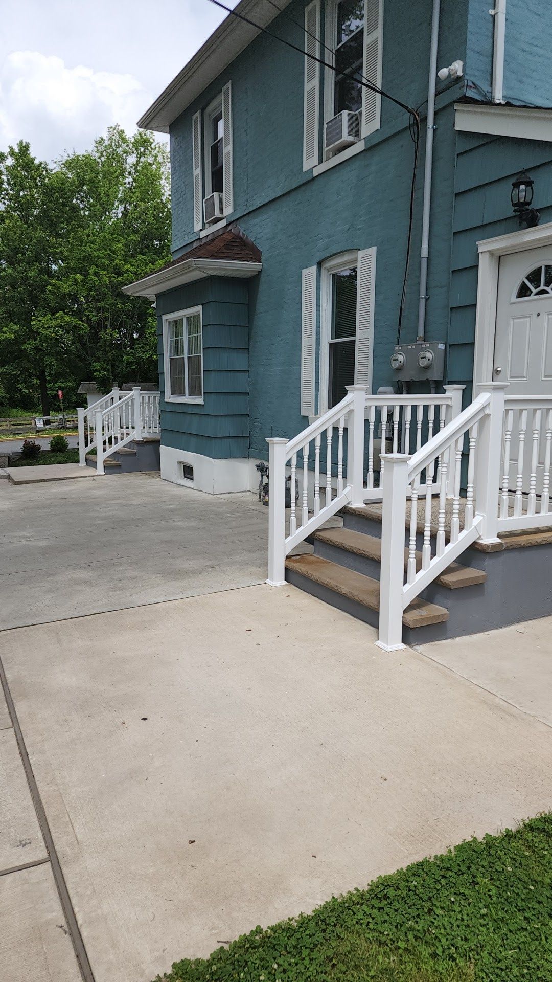 A blue house with white stairs and a white railing.