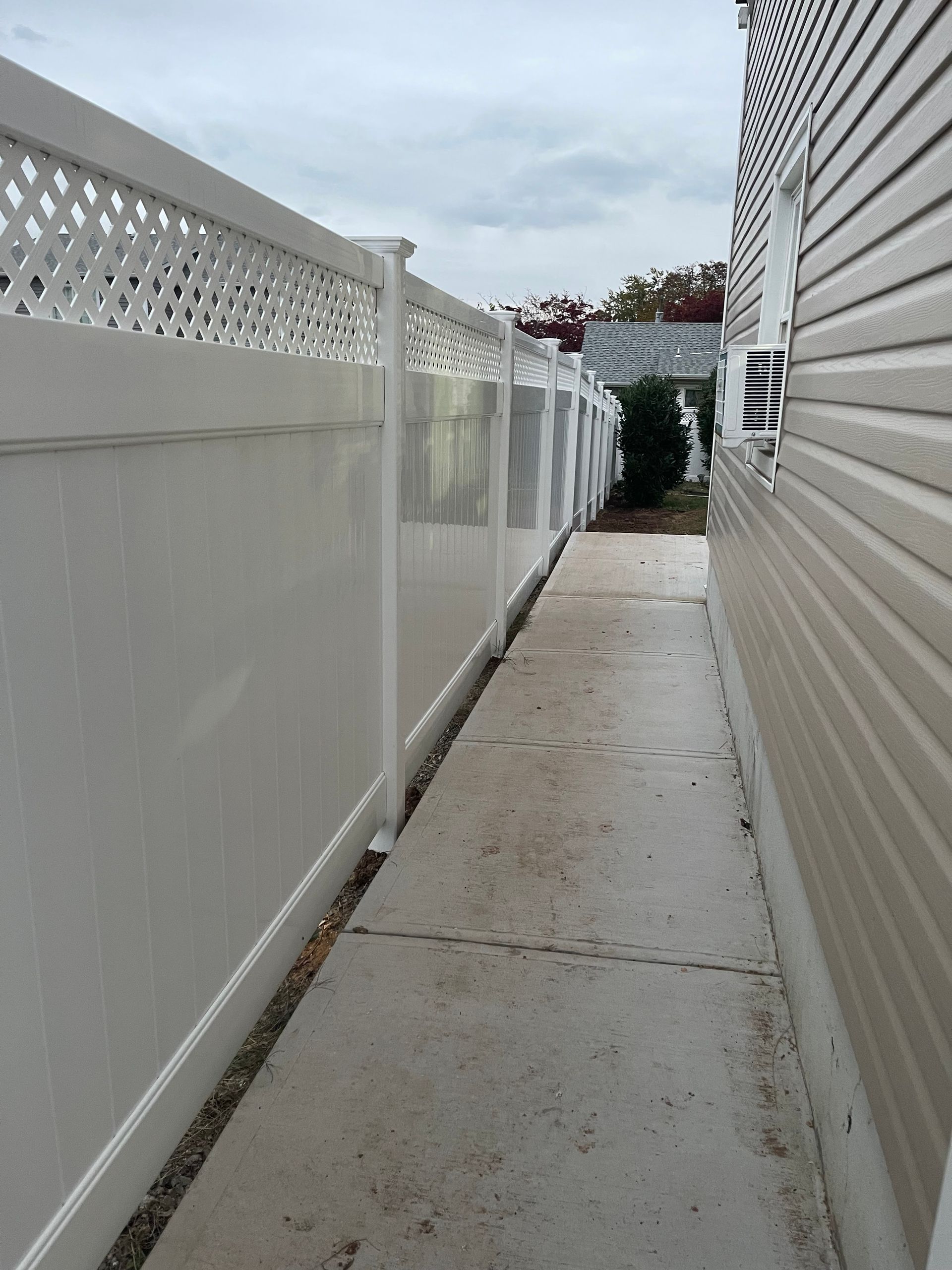 A white fence along the side of a house