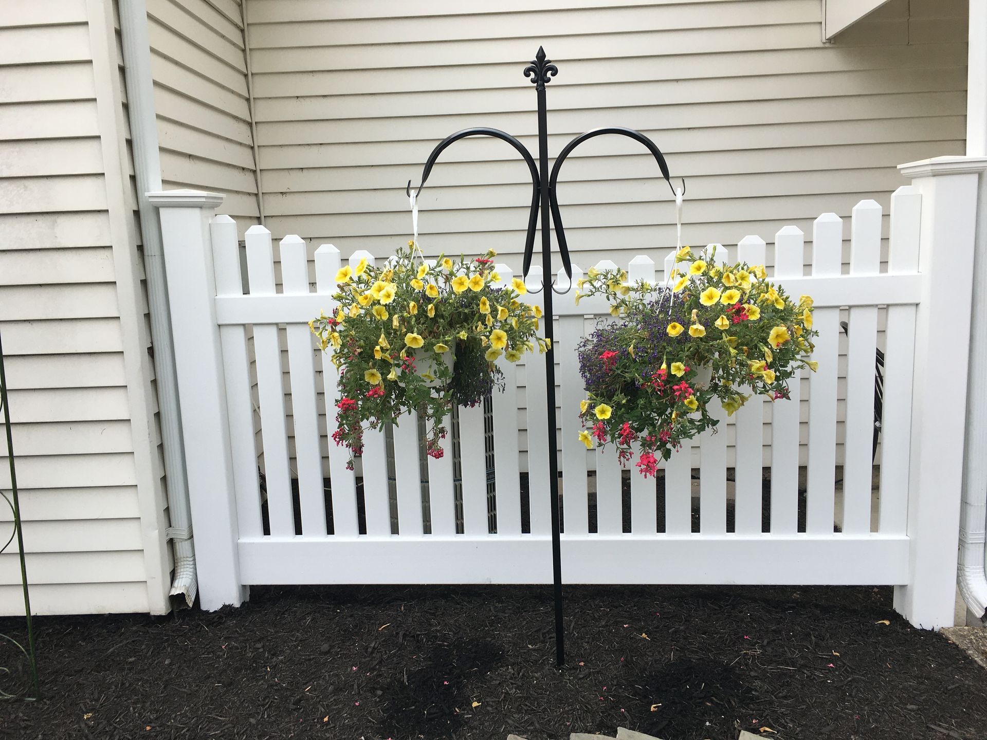 A white picket fence with flowers hanging from it