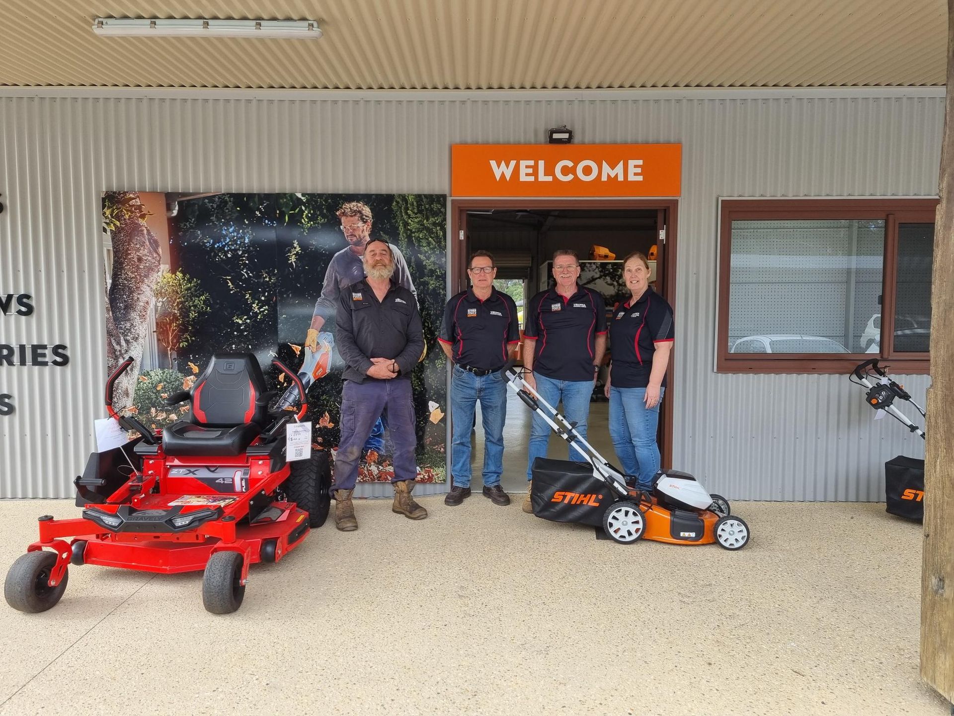 Four people stand outside a store entrance with a 