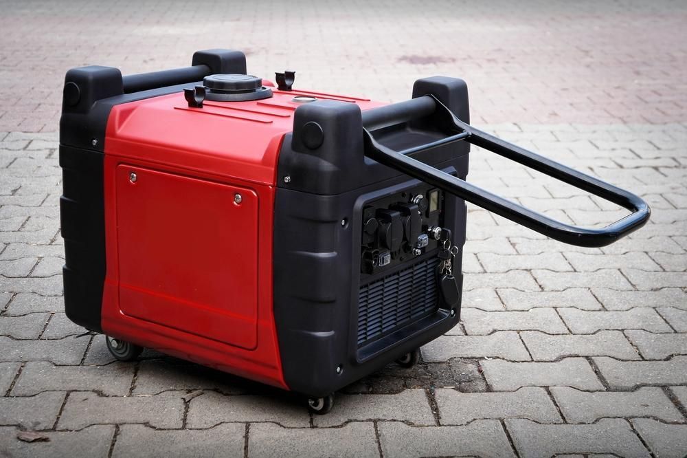 A Red and Black Generator is Sitting on a Brick Sidewalk — Urunga Chainsaw and Mower in Urunga, NSW