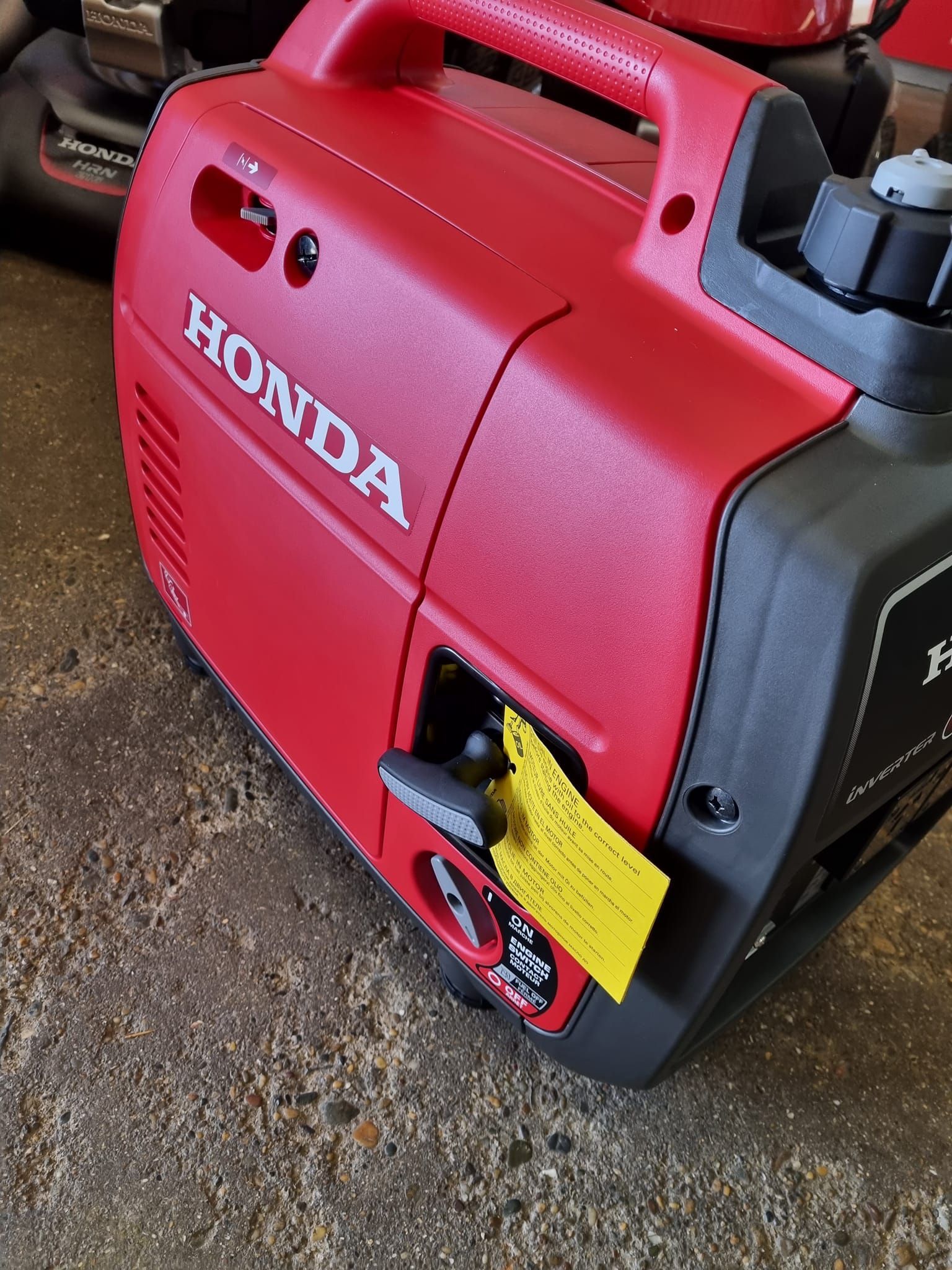 A Red Honda Generator is Sitting on the Ground — Urunga Chainsaw and Mower in Mid North Coast, NSW