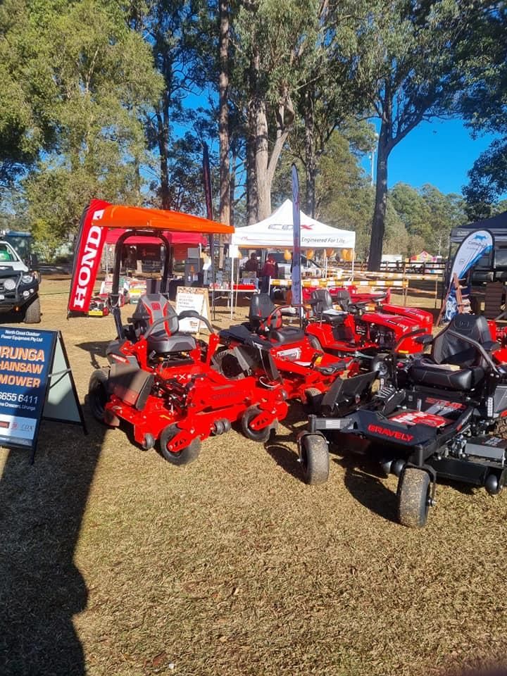 A Row of Red Honda Lawn Mowers Are Parked in a Field — Urunga Chainsaw and Mower in Urunga, NSW