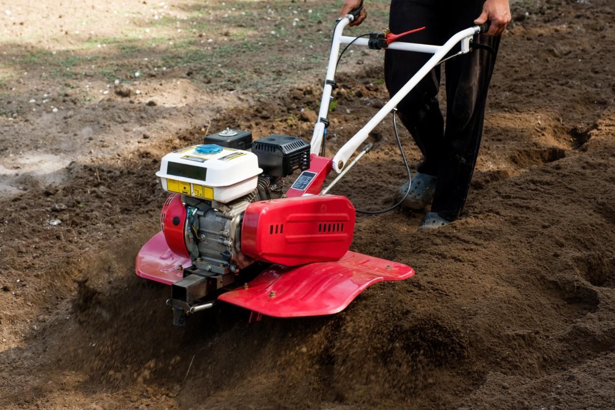 A Person is Using a Small Tractor to Dig a Hole in the Ground — Urunga Chainsaw and Mower in Urunga, NSW