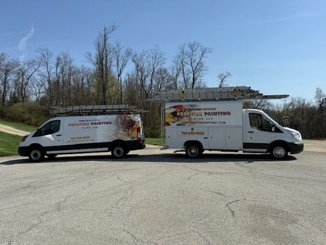 Two vans are parked next to each other in a parking lot. Two vans are parked next to each other in a parking lot.