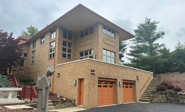 A large brick house with two garage doors and stairs