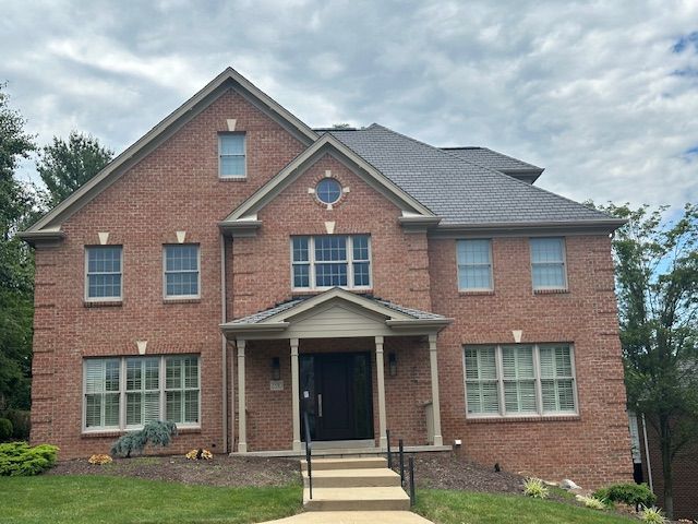 A large brick house with a gray roof and many windows