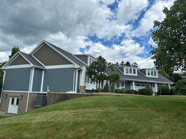 A large house is sitting on top of a grassy hill.