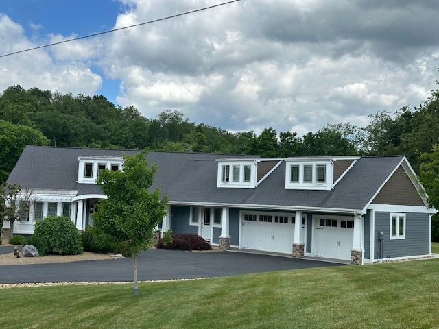 A large house with a gray roof and white trim