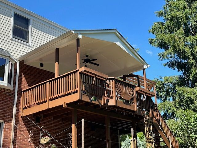 A brick house with a large wooden deck and stairs