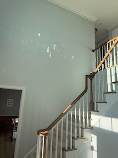 A staircase with white steps and a wooden railing in a house.