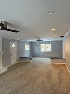 An empty living room with a ceiling fan and a fireplace.