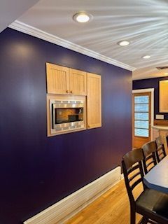 A kitchen with purple walls and wooden cabinets