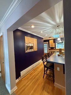 A kitchen with purple walls , hardwood floors , and a large island.