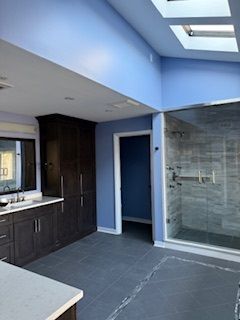 A bathroom with blue walls and a walk in shower