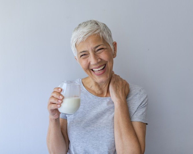 A woman drinking milk smiling
