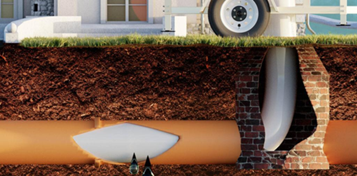 Cross-section view showing an underground sewer pipe being repaired with a white liner inside a brick manhole.