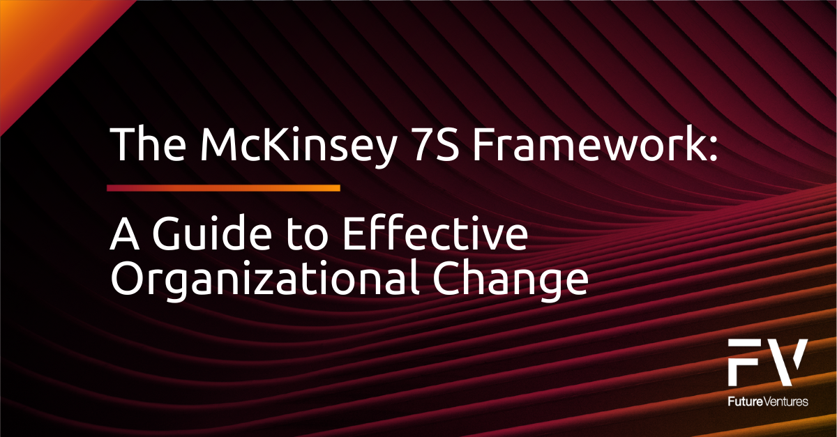 A man and a woman are sitting at a table with laptops.