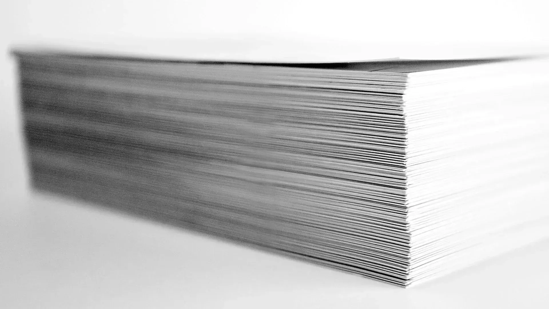 A black and white photo of a stack of cards on a table.