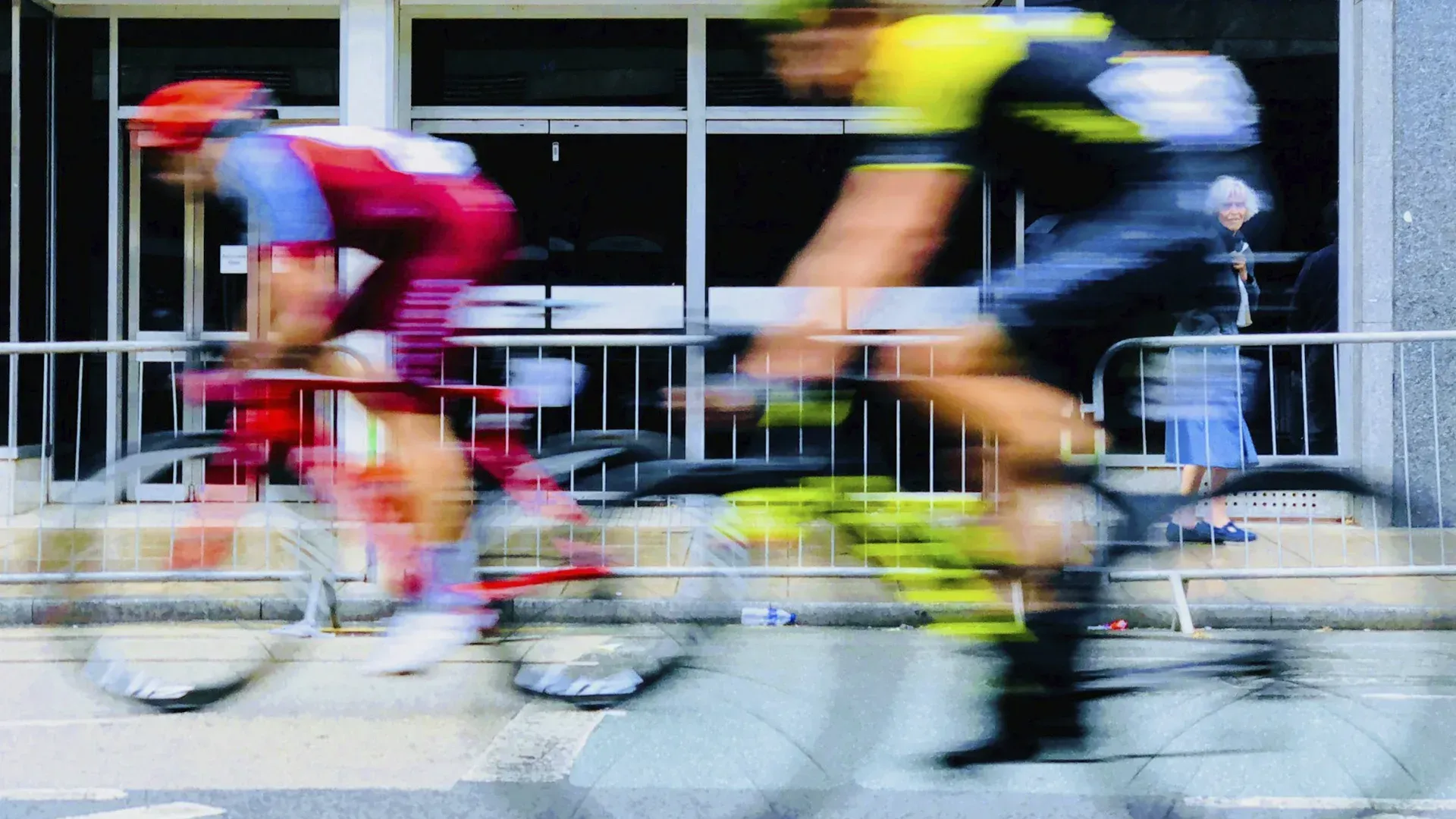 A blurry picture of two men riding bicycles down a street.