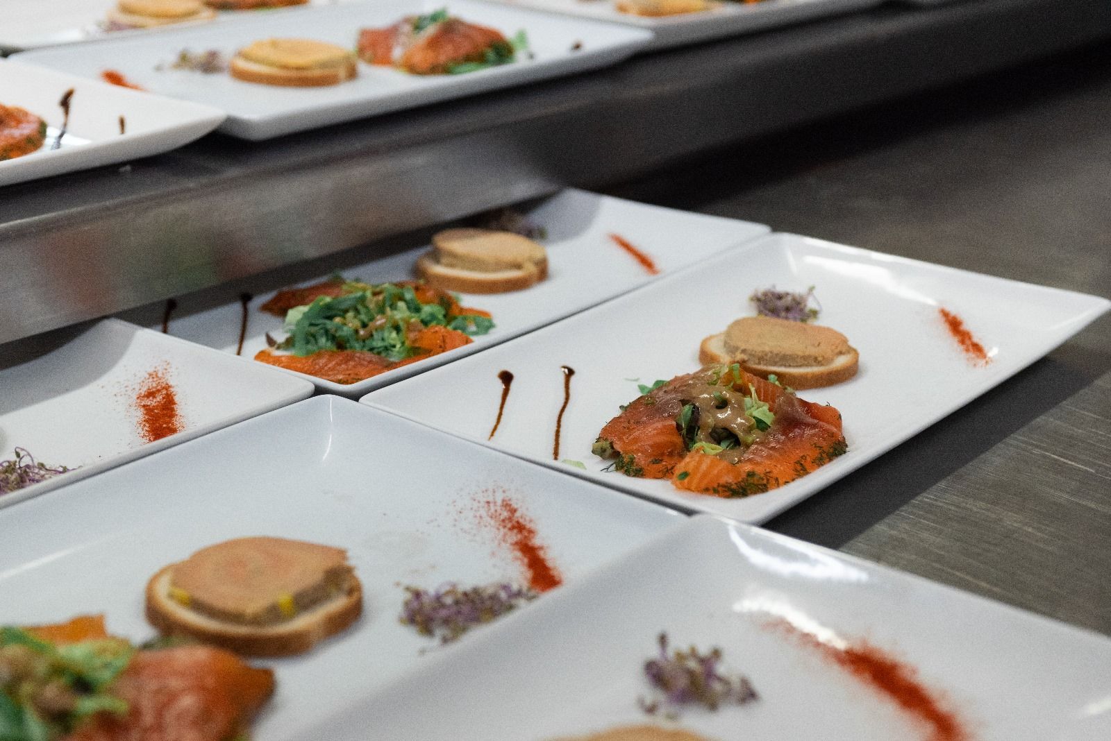 Une rangée d'assiettes blanches remplies de nourriture sur un comptoir.
