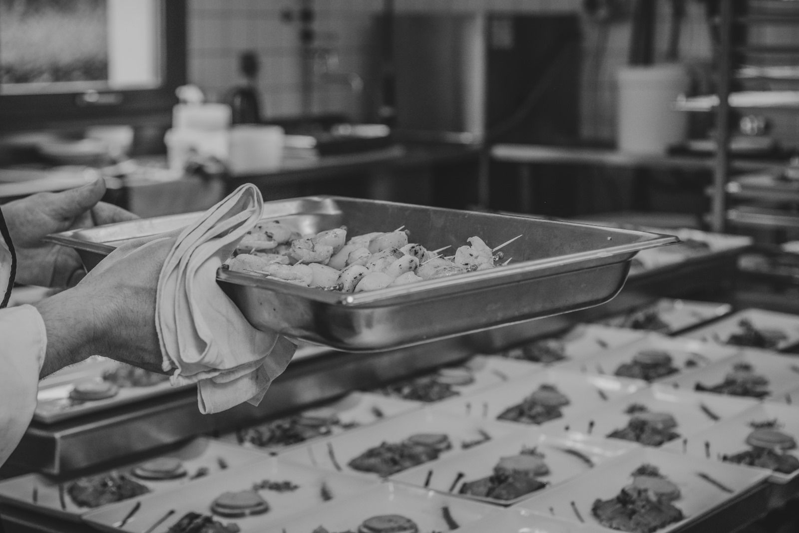 Une personne tient un plateau de nourriture dans une cuisine.