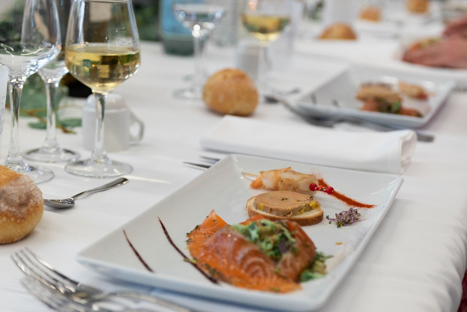 Une assiette de nourriture est posée sur une table à côté d'un verre de vin.