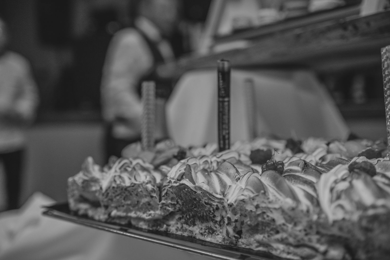 Une photo en noir et blanc d'un plateau de nourriture avec un homme en arrière-plan.