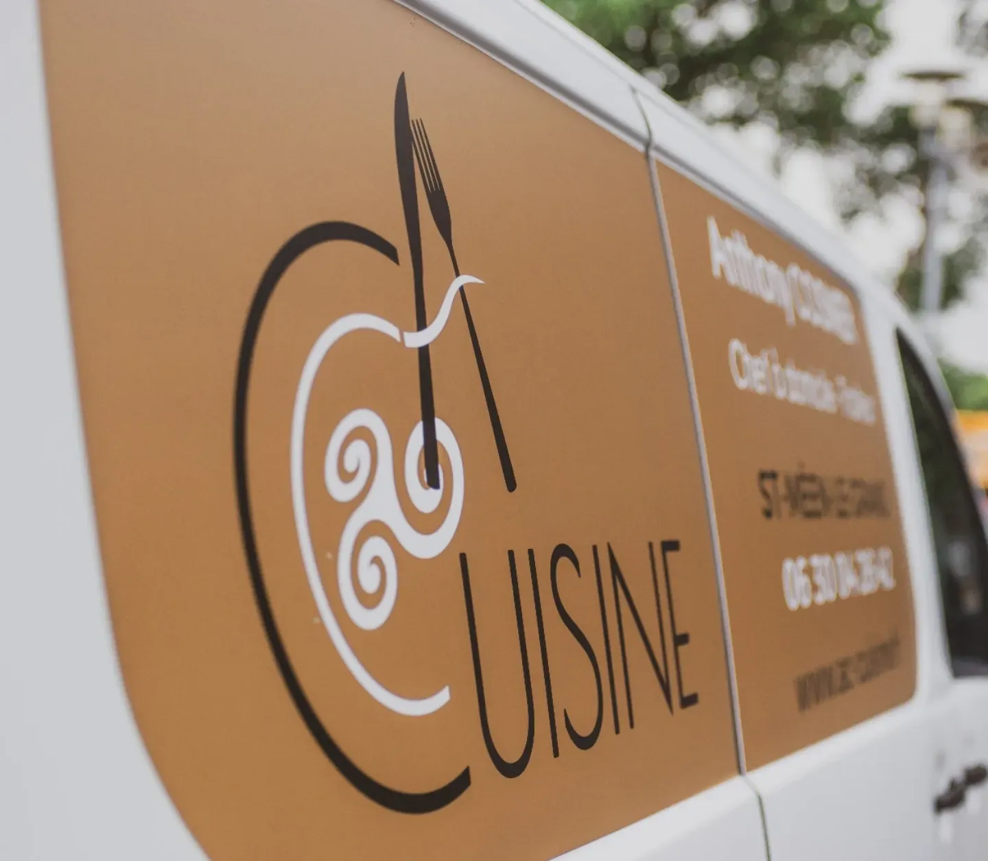 Une camionnette blanche avec le mot cuisine sur le côté