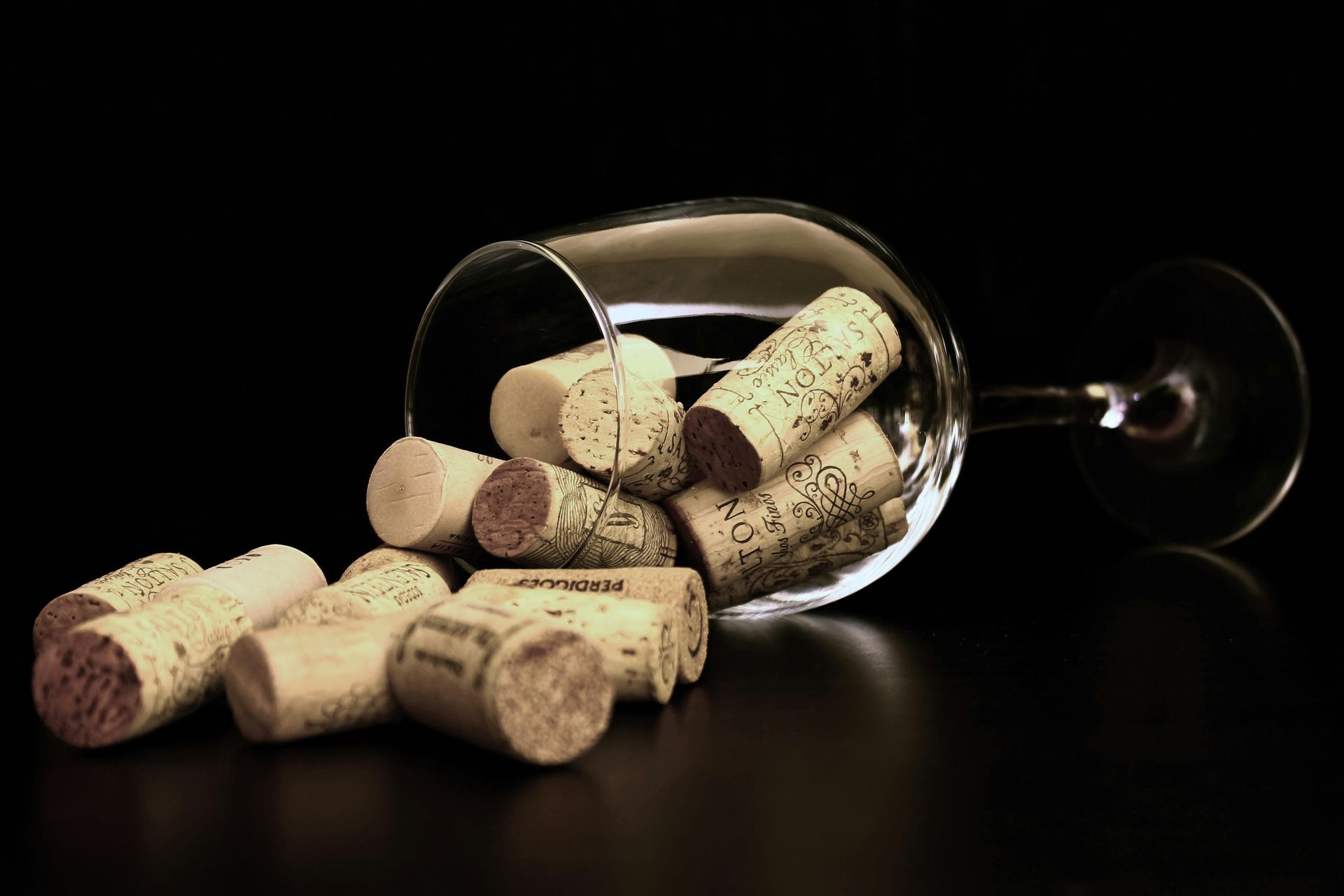 Un verre de vin est rempli de bouchons sur une table.
