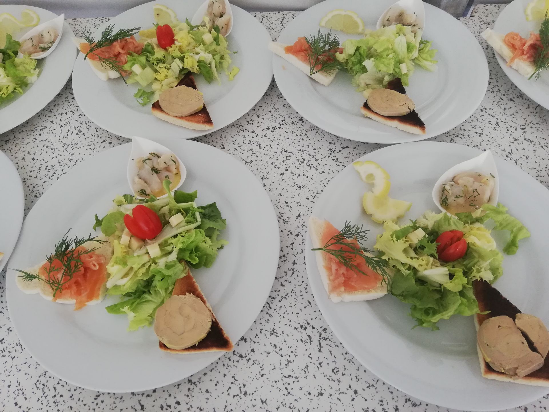 Une rangée d'assiettes blanches avec de la nourriture dessus sur une table