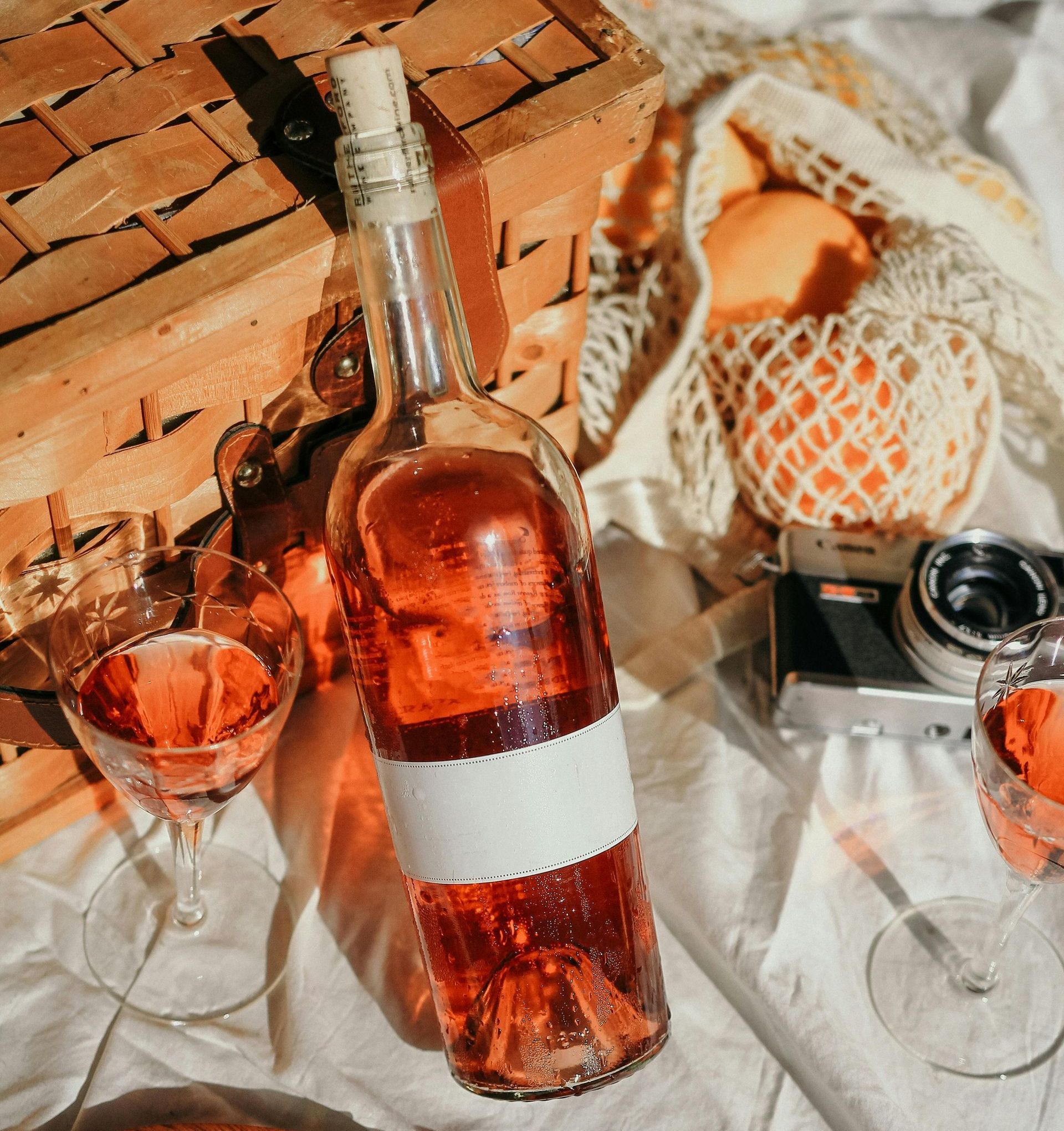 Une bouteille de vin est posée sur une table à côté de verres et d'un appareil photo