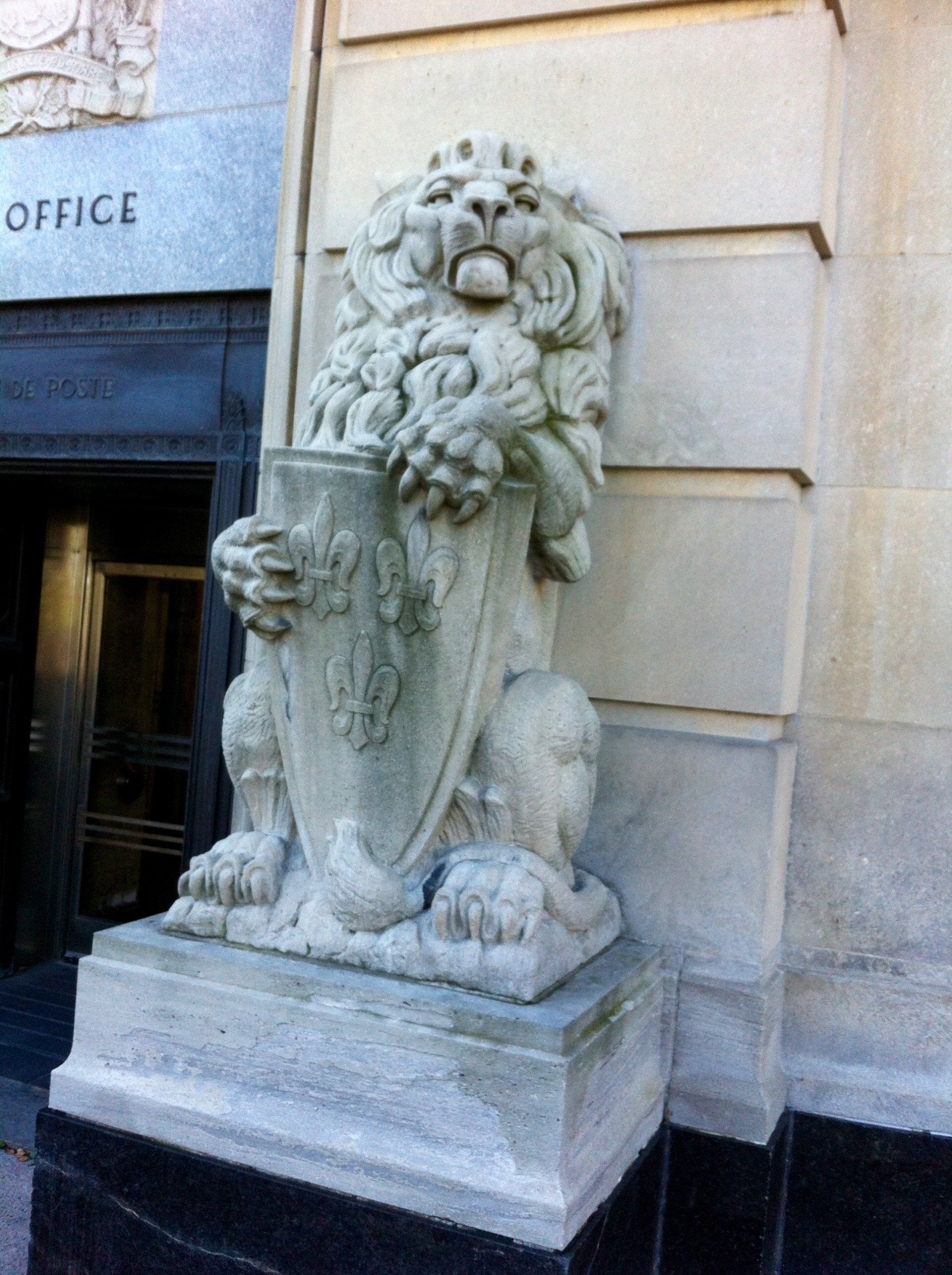 A statue of a lion holding a shield in front of an office building