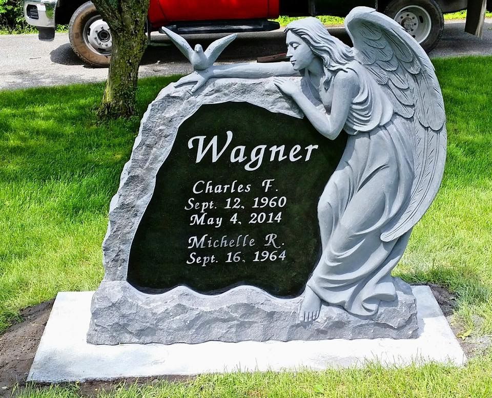 Pierre tombale ornée d'une statue d'ange ; le nom « Wagner » et des dates sont inscrits sur un panneau noir.