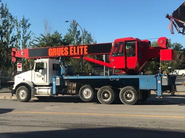 Un camion Grues Elite est garé sur le bord de la route