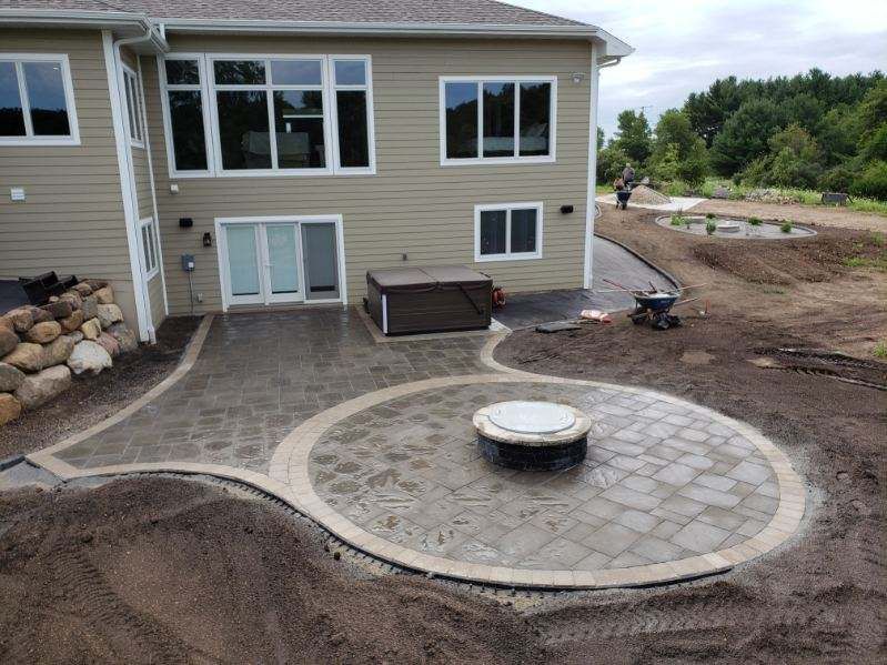 A large house with a patio and a fire pit in front of it.