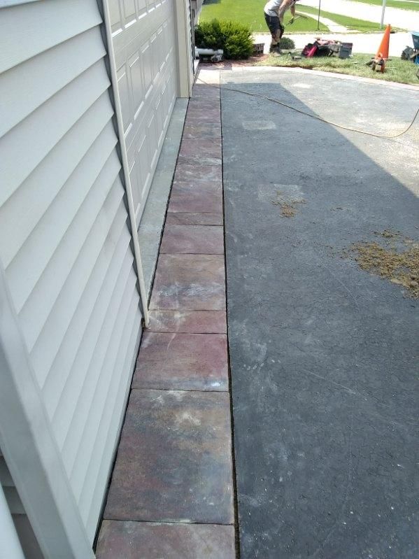 A sidewalk is being built next to a garage door