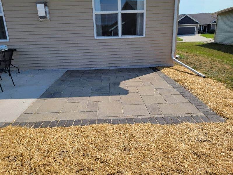 A patio with a table and chairs in front of a house.