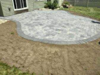 A patio is being built in the backyard of a house.