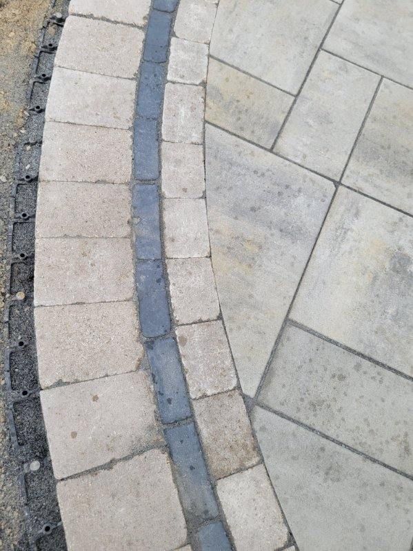 A close up of a brick walkway with a blue border.