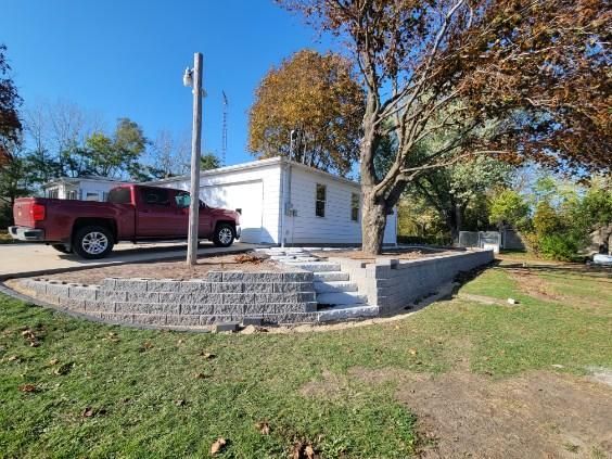 A red truck is parked in front of a white house.