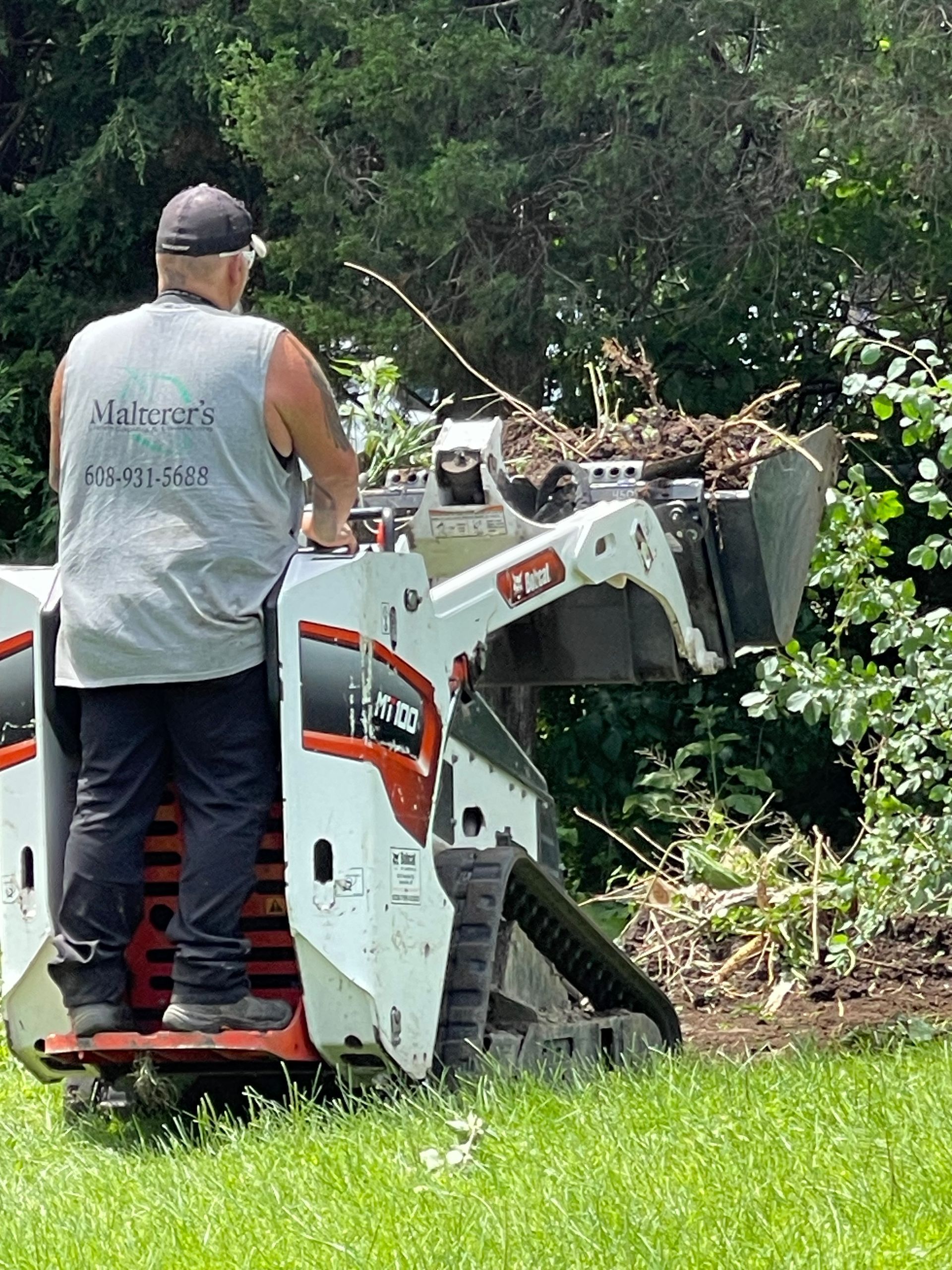 Man running landscaping machine to clear overgrowth