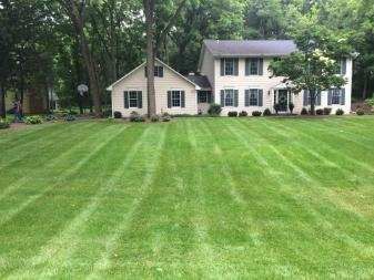 A large house with a lush green lawn in front of it.