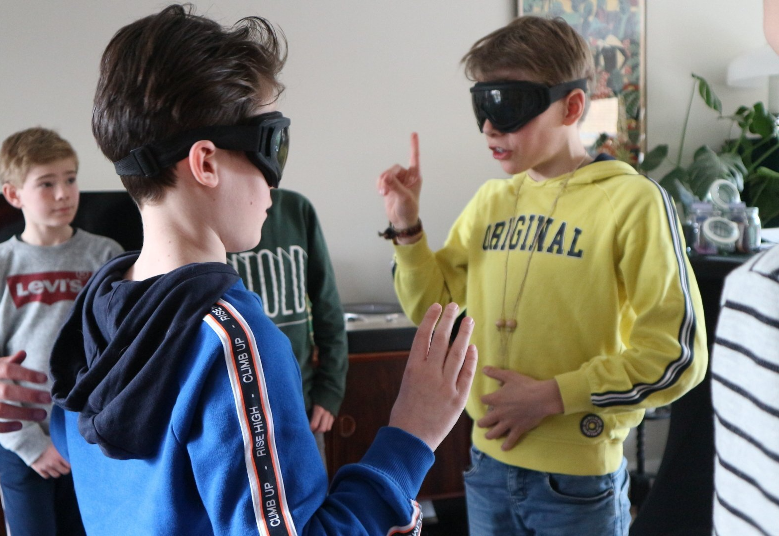 Een jongen die een geel sweatshirt draagt ​​met het woord origineel erop