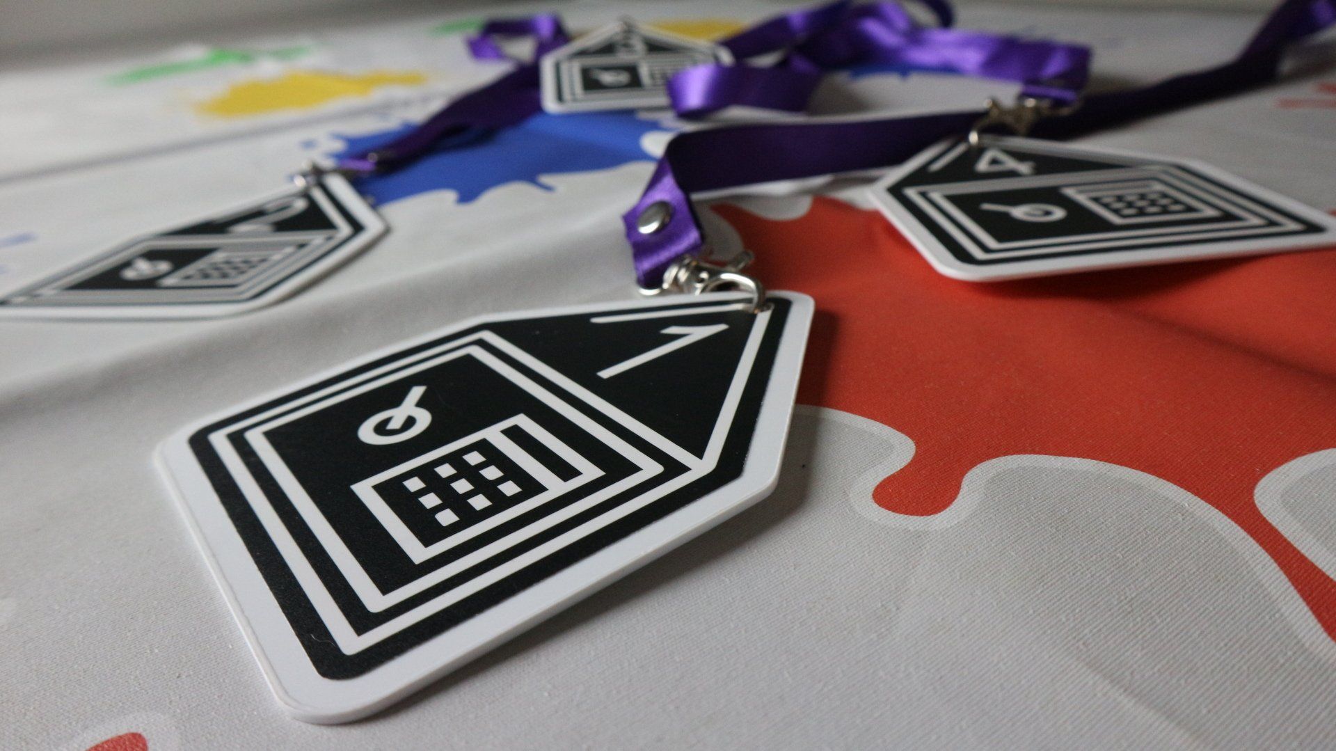 Een paarse sleutelkoord met een zwart-witte medaille erop